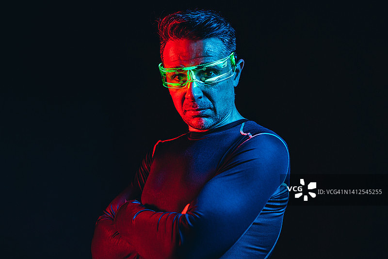 佩戴绿色灯光电子眼镜、身穿蓝色紧身T恤的男子图片素材