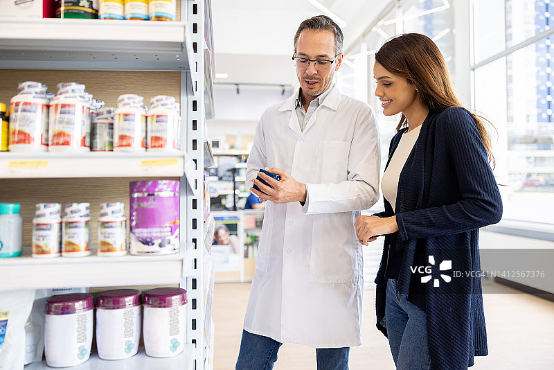 在药剂师的帮助下，女人在药店购买药品图片素材