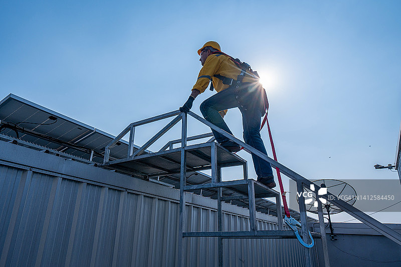 工人佩戴安全带和安全绳在工业屋顶高处作业图片素材