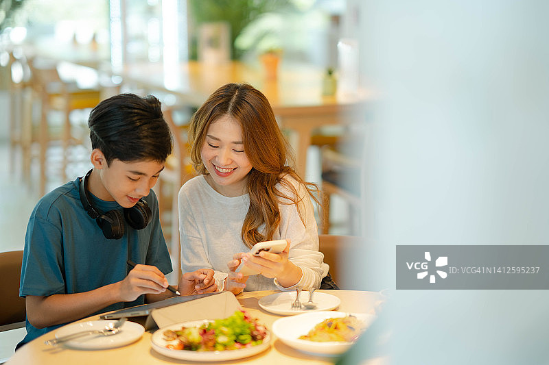 两个年轻的兄弟姐妹一起吃午饭图片素材