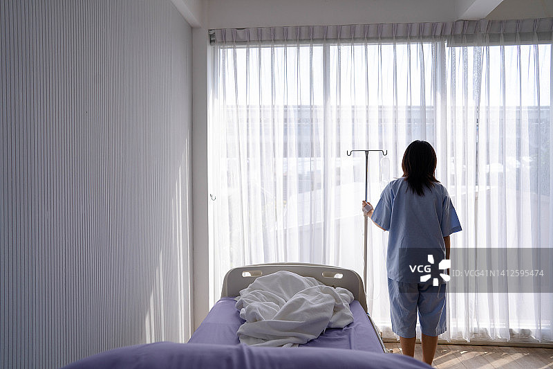 生病的病人躺在医院病房里，感到担忧图片素材