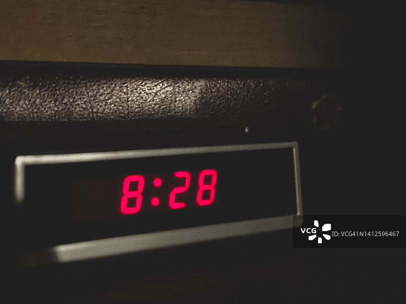 黑暗房间里书堆前的数字闹钟图片素材