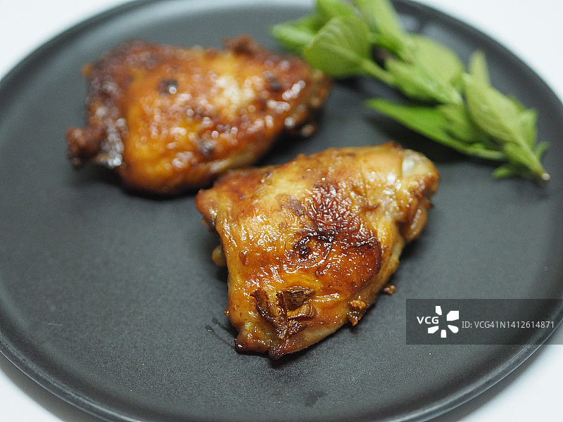 不锈钢烤架烤鸡：黑色烤盘上的熟肉图片素材