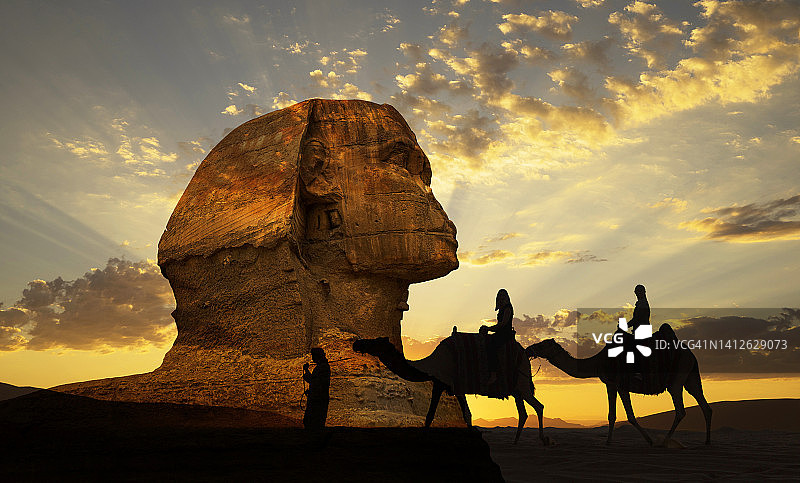 观看狮身人面像的单峰骆驼上的游客图片素材