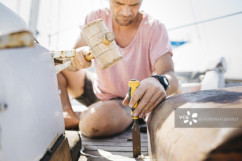 男人在船坞上修复帆船图片素材