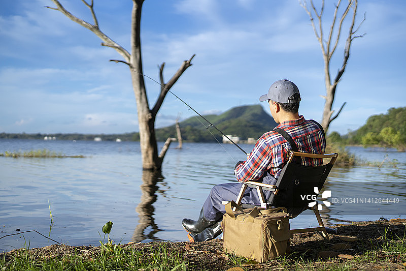 男人坐在水边钓鱼图片素材