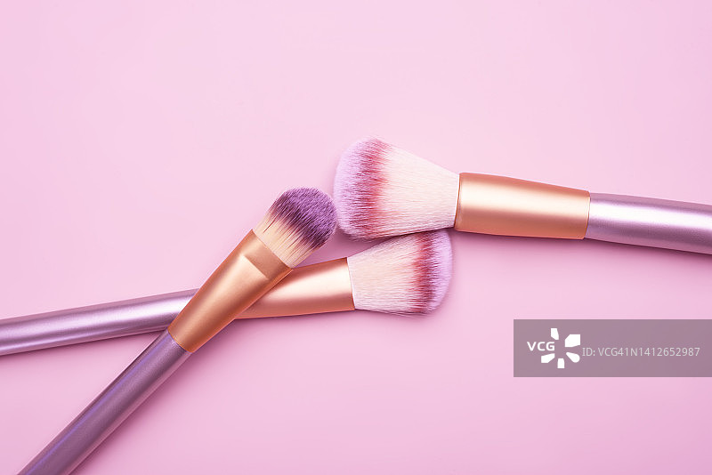 粉色背景上的化妆刷图片素材