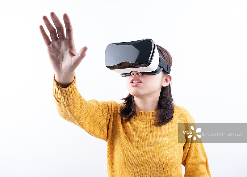 元宇宙：戴VR眼镜的女人体验虚拟现实人工智能图片素材