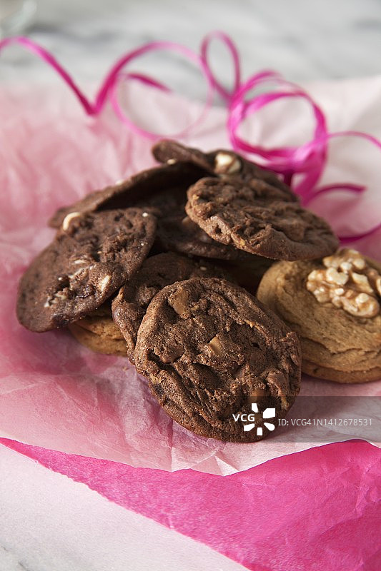 纸巾上的饼干堆与粉色丝带图片素材