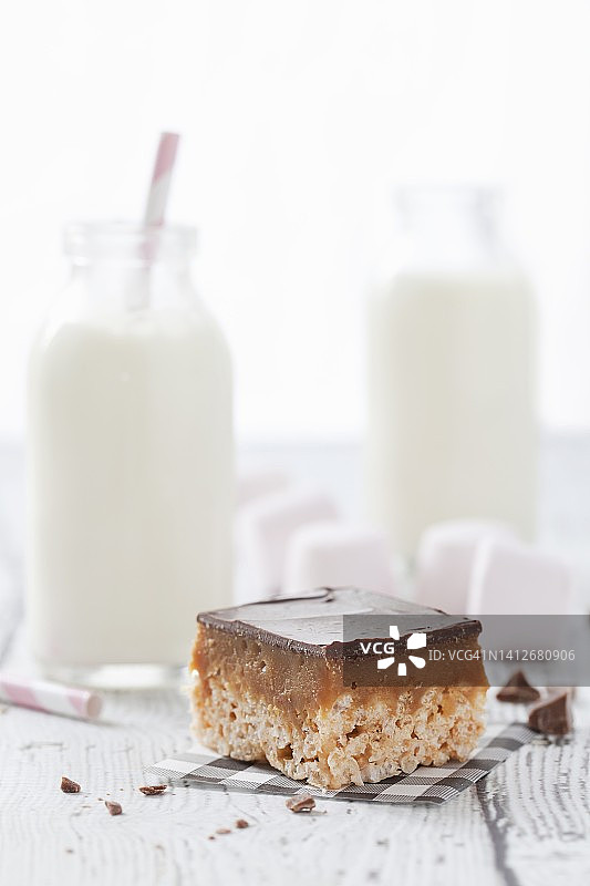 与牛奶和棉花糖一起食用的百万富翁巧克力焦糖脆皮蛋糕图片素材