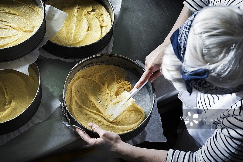 用刮刀将蛋糕面糊摊入蛋糕模具图片素材