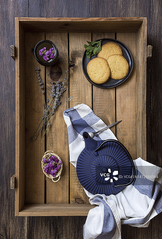 木盒装绿茶、茶杯、食用花草和饼干图片素材