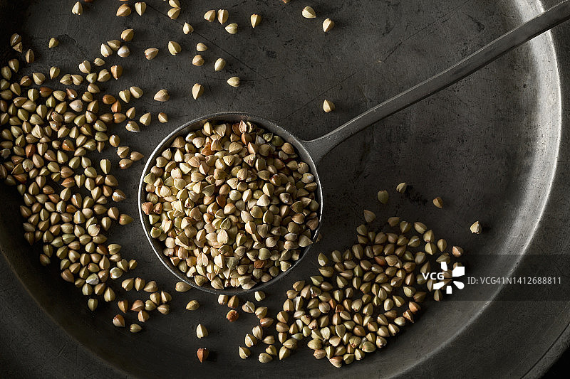 锡盘上金属勺子里的荞麦图片素材