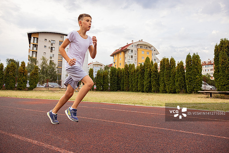 小孩在跑道上慢跑图片素材