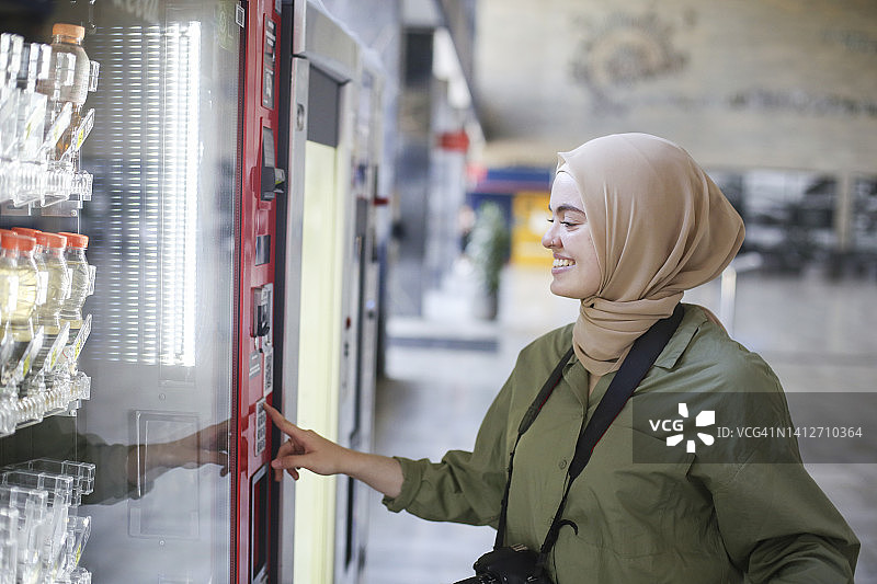 游客在车站使用自动售货机图片素材