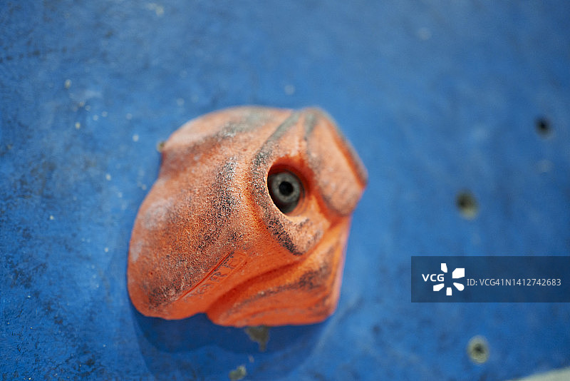 蓝色墙壁上的橘色手柄，带有一个黑点图片素材