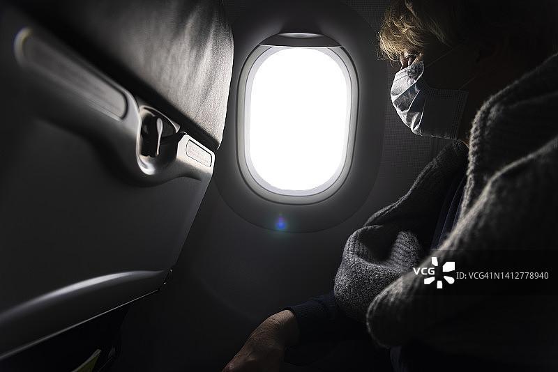 飞机上黑暗中看窗外的女人图片素材
