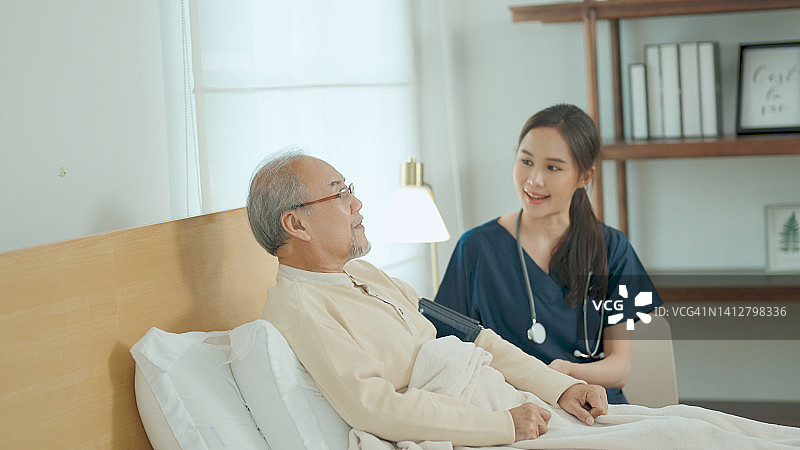 年轻护士在家中照顾年长的叔叔图片素材