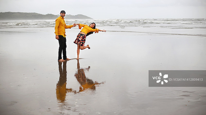 在印度果阿热带沙滩上跳舞的年轻夫妇图片素材