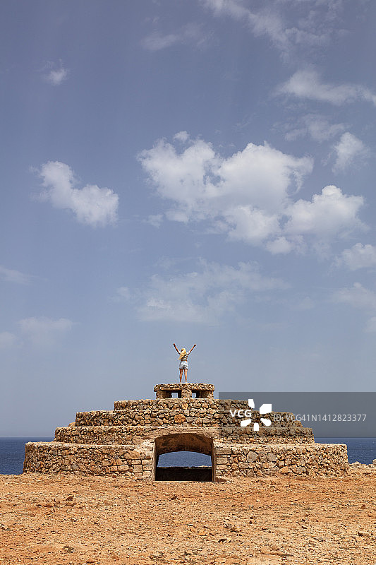 在面向大海的旧建筑上的女人图片素材