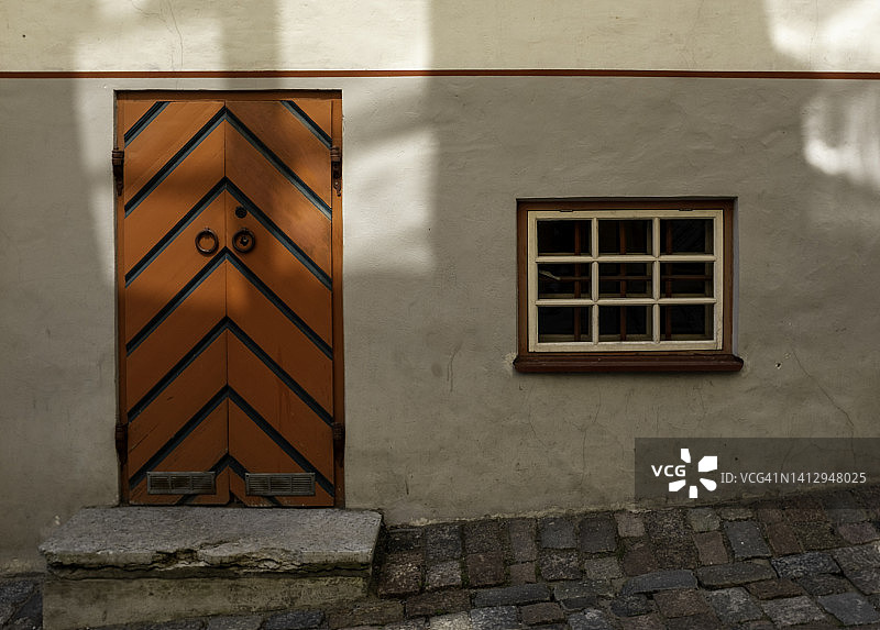 爱沙尼亚塔林老城区鹅卵石街道上的华丽橙色门窗图片素材