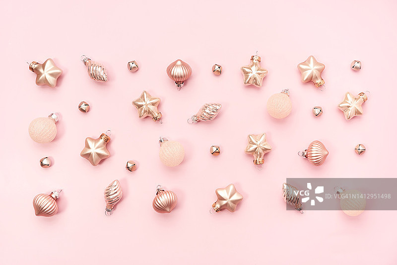 圣诞树装饰品以矩形形状摆放在粉红色背景上，新年庆祝概念图片素材