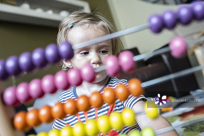 宝宝在家玩木制彩色算盘玩具图片素材