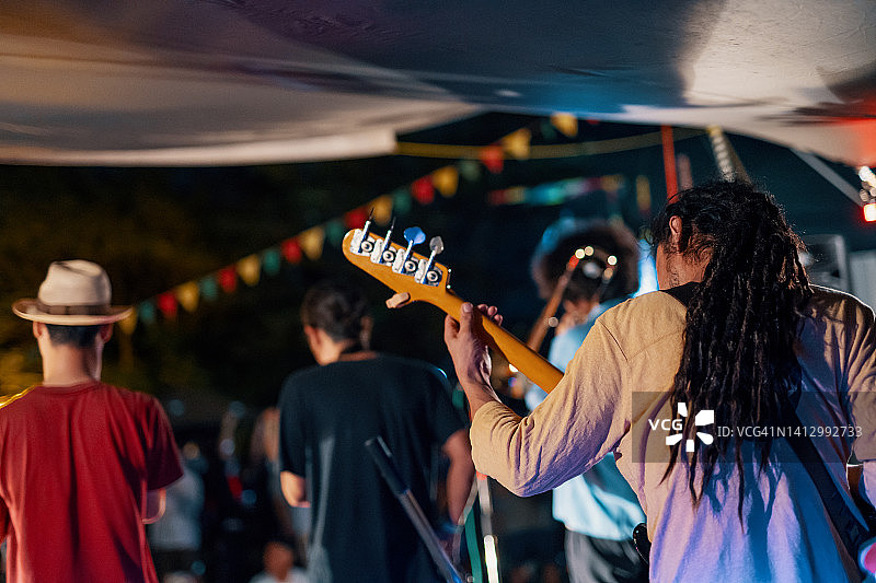 音乐团体在户外音乐节上进行现场音乐会的背影图片素材