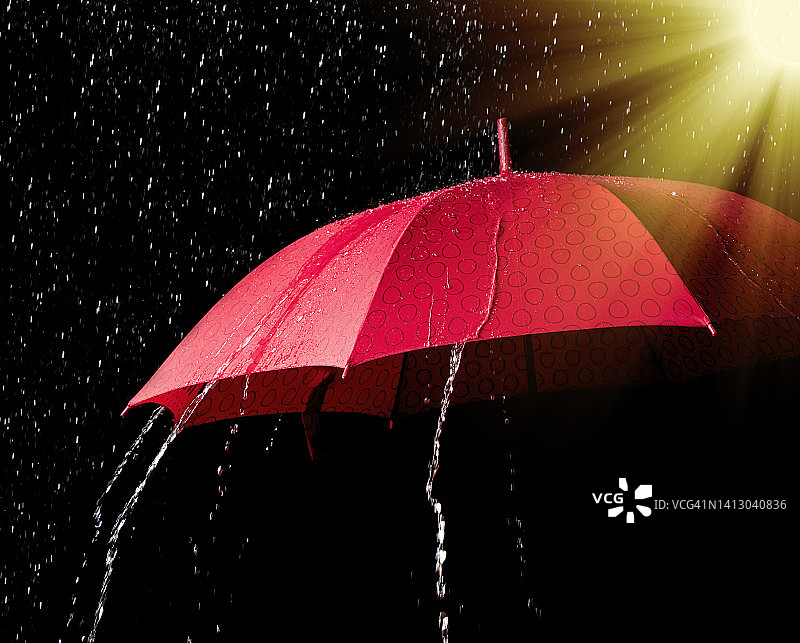阳光照射下带有雨滴的开放式雨伞图片素材