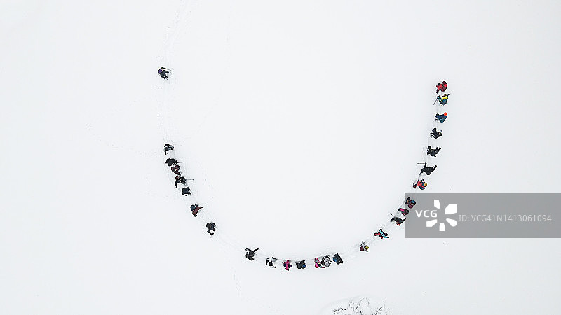 冬季雪林中徒步人群的航拍视角图片素材