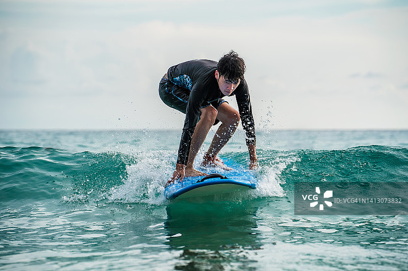 穿着泳衣在海上冲浪的男人图片素材