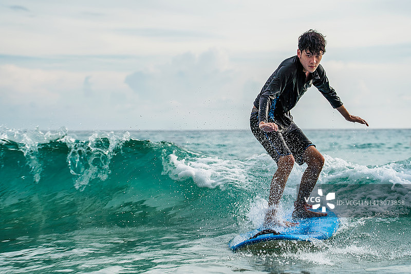 穿着泳衣在海上冲浪的男人图片素材