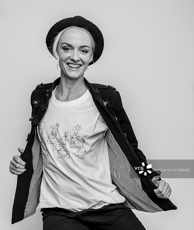 戴着猪肉馅饼帽的微笑女人在工作室摆姿势 - 灰色背景，积极的微笑，看着相机图片素材