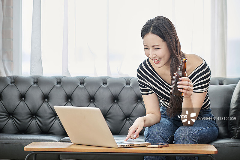 在家使用笔记本电脑、参加网络讲座、微笑的女人图片素材