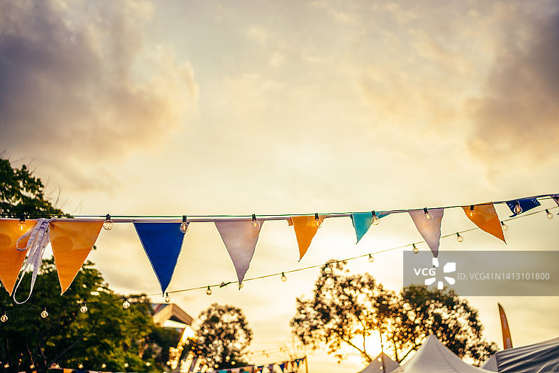 黄昏天空下的彩旗和灯泡图片素材