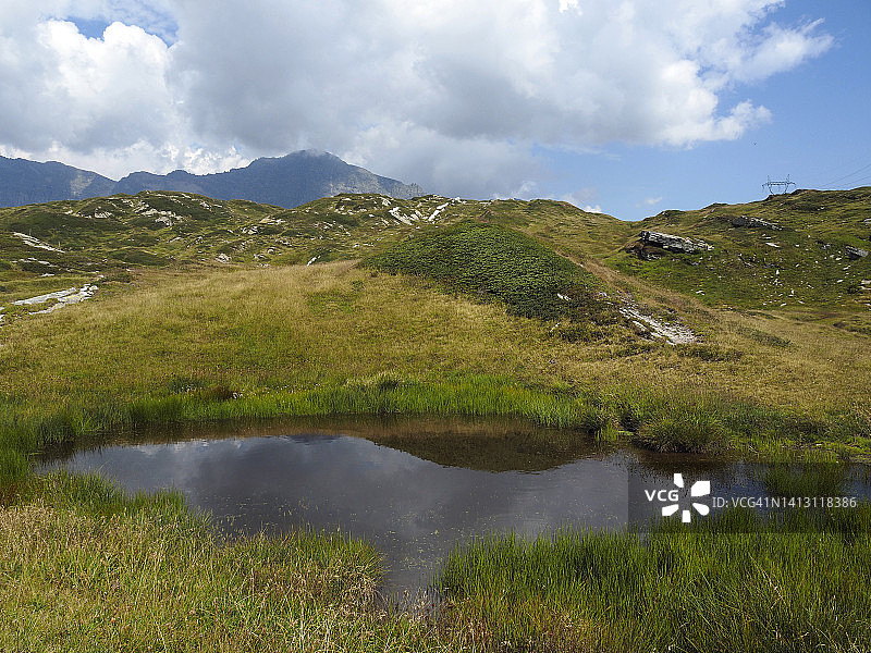 瑞士圣贝纳迪诺山口的高山牧场和小池塘图片素材