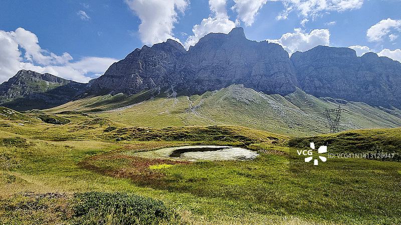 瑞士圣贝纳迪诺山口的皮佐乌切洛山和卡夫里奥拉山与高山池塘图片素材