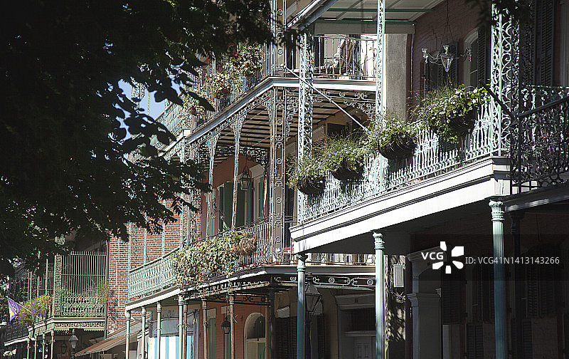 新奥尔良法国区带有锻铁围栏阳台和花篮的克里奥尔联排别墅仰视图片素材