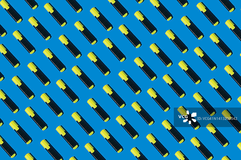 蓝色背景上的黄色荧光笔图案：学习办公主题图片素材