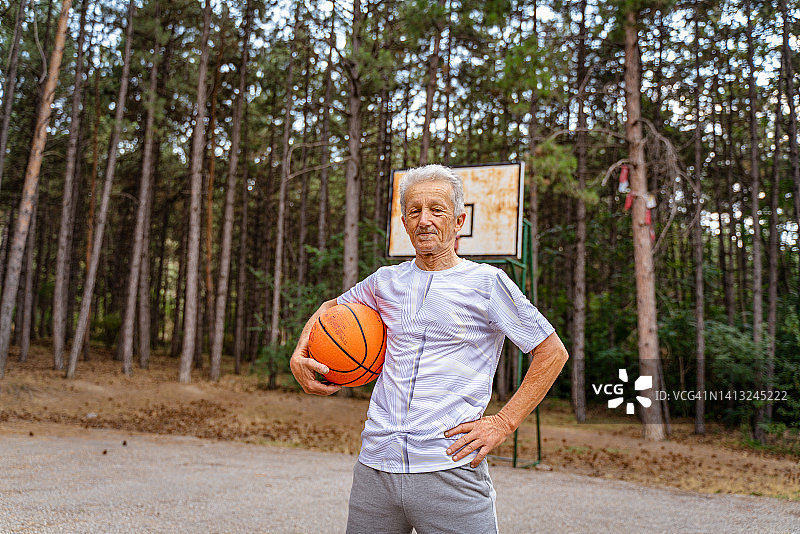 在篮球场上摆姿势的活跃老年男人图片素材