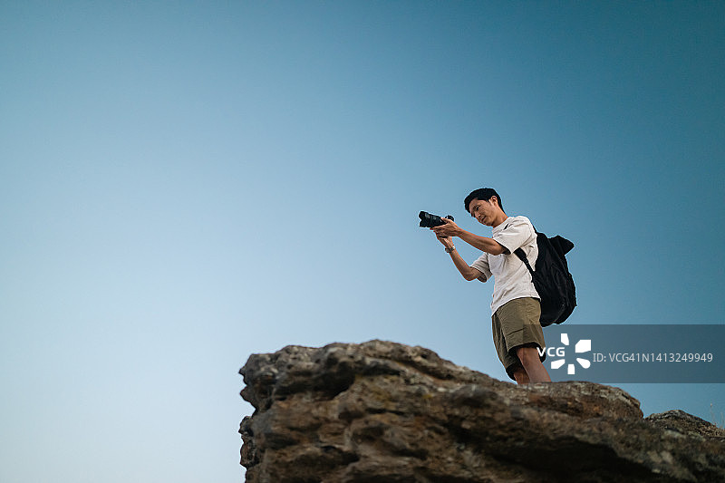 年轻摄影师在历史古镇拍摄日落图片素材