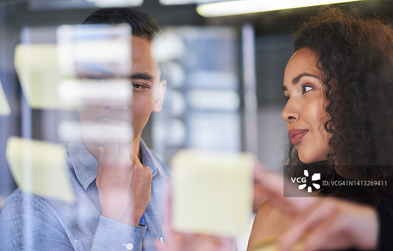 商务团队在会议室的玻璃墙上用便签计划策略图片素材