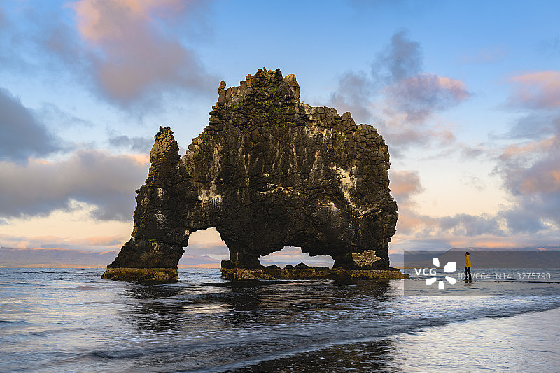 游客在冰岛欣赏日落时奇特的岩层图片素材