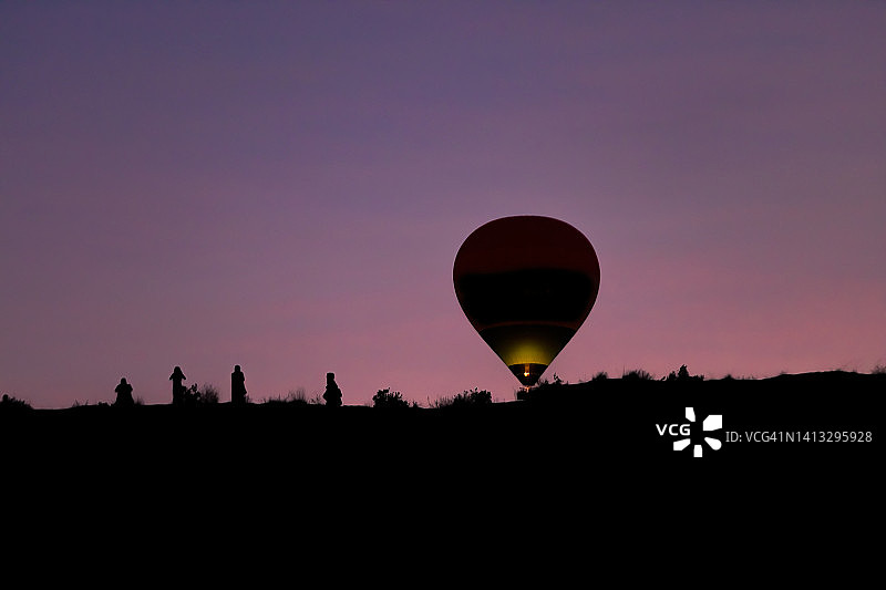 卡帕多奇亚的热气球与拍照的女性图片素材