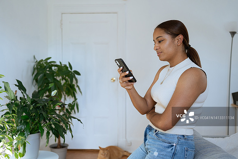 在家使用手机的年轻黑人女性图片素材