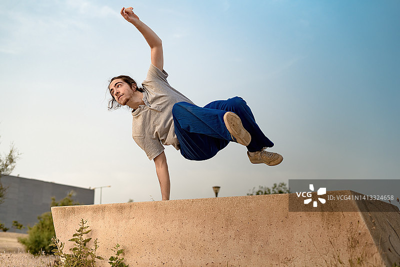 在公园里跳跃、跳特技和自由奔跑、跳舞的马尾辫男孩图片素材