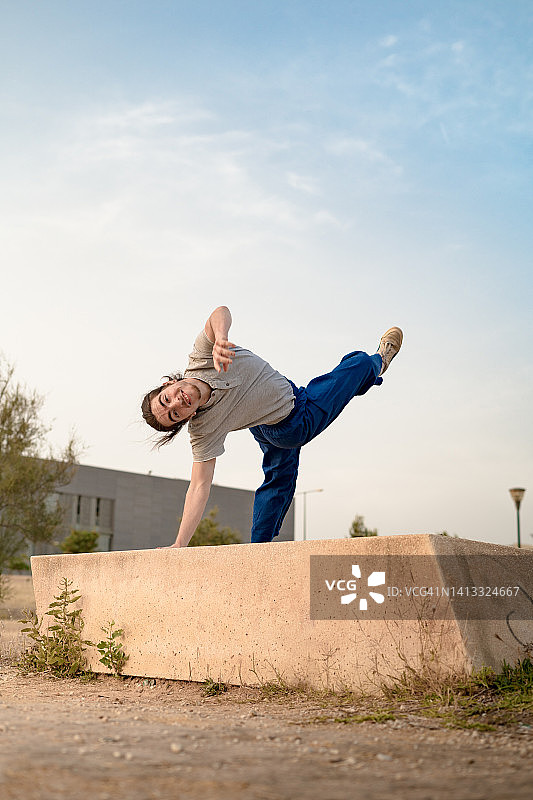 在公园里跳跃、跳特技和自由奔跑、跳舞的马尾辫男孩图片素材