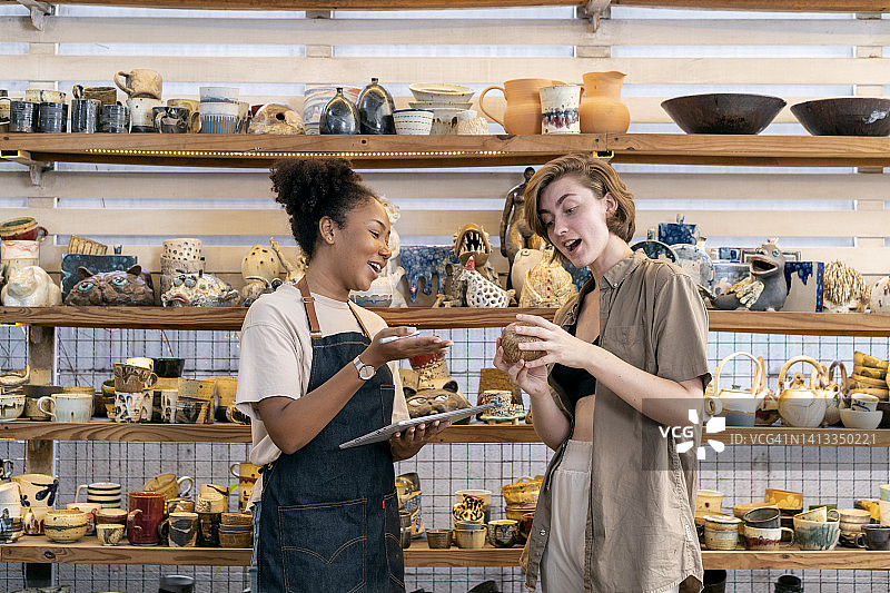 女人在商店向店主购买工艺品图片素材