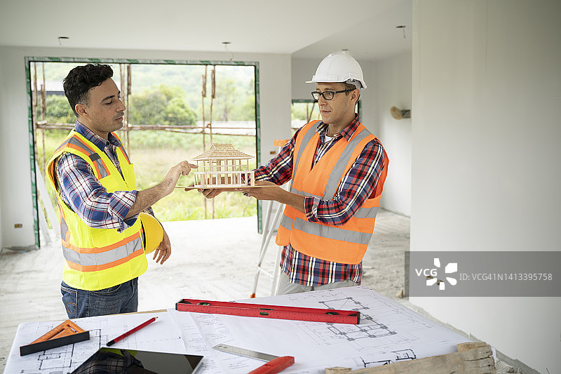 建筑承包商和土木工程师在建筑工地合作图片素材