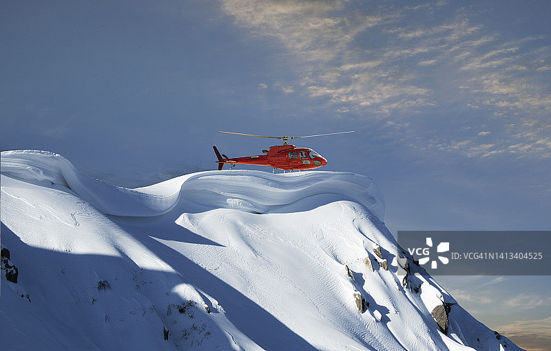 直升机降落在雪山山脊上图片素材